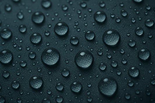 Regendruppels op waterdicht tasmateriaal, van dichtbij